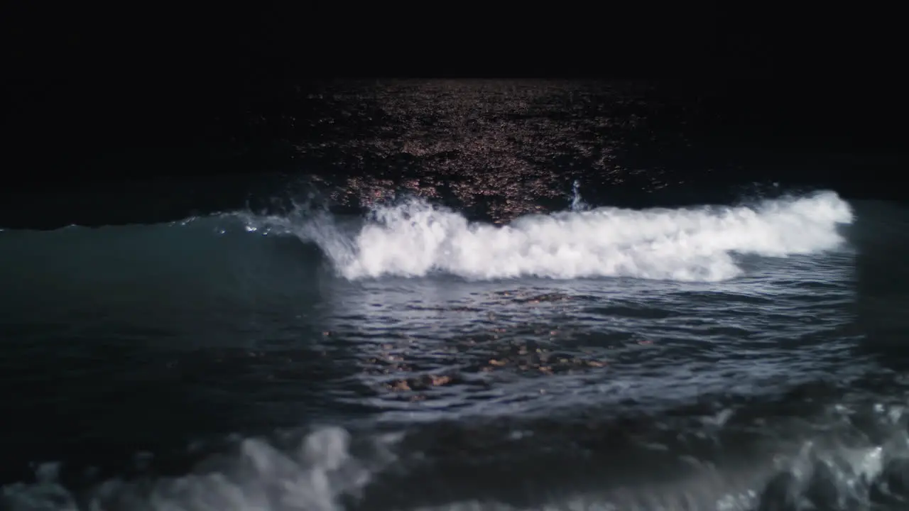 Night waterscape with waving sea rolling in on the shore