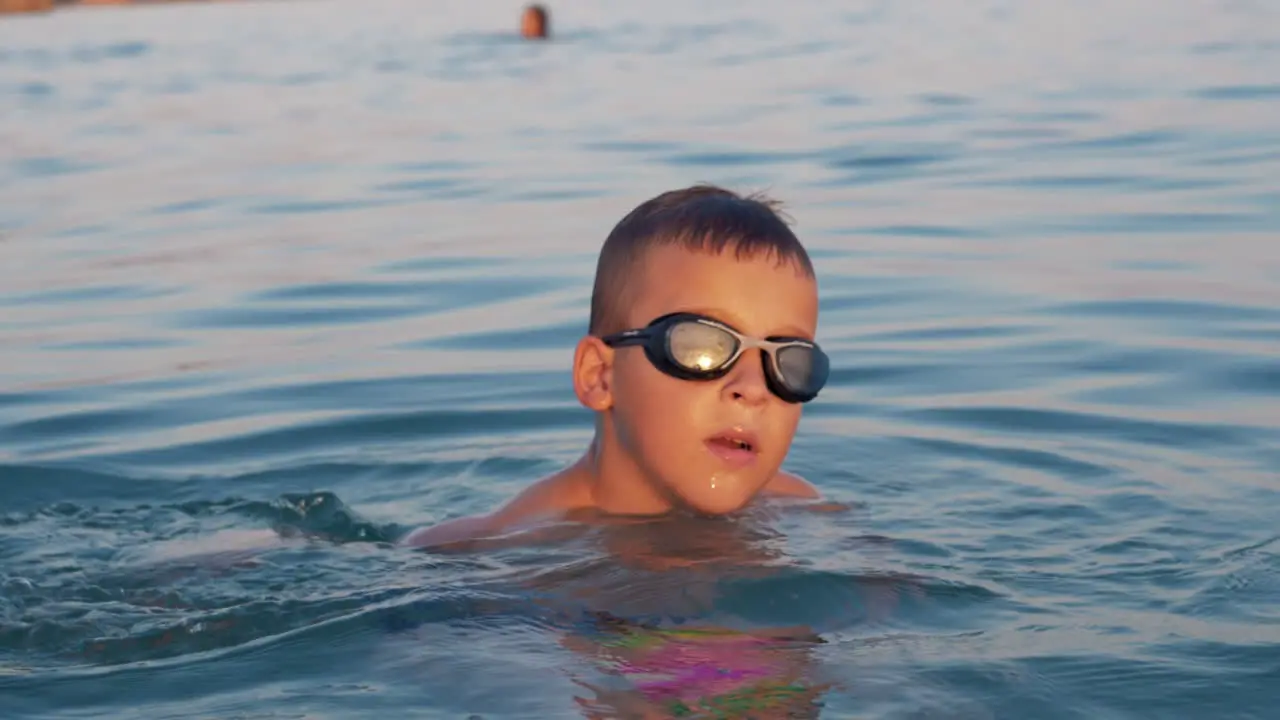 Kid with ball bathing in the sea