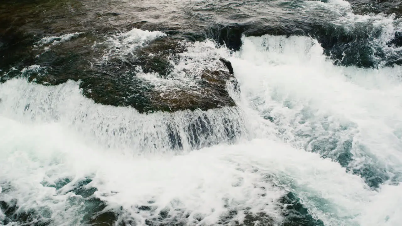 View from above of the stream of a clear mountain river 120 fps slow motion video