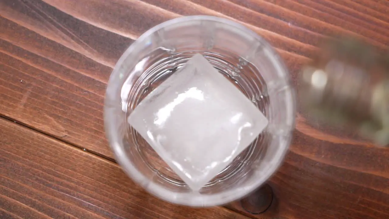 Whiskey being poured into a glass with ice in slow motion HD