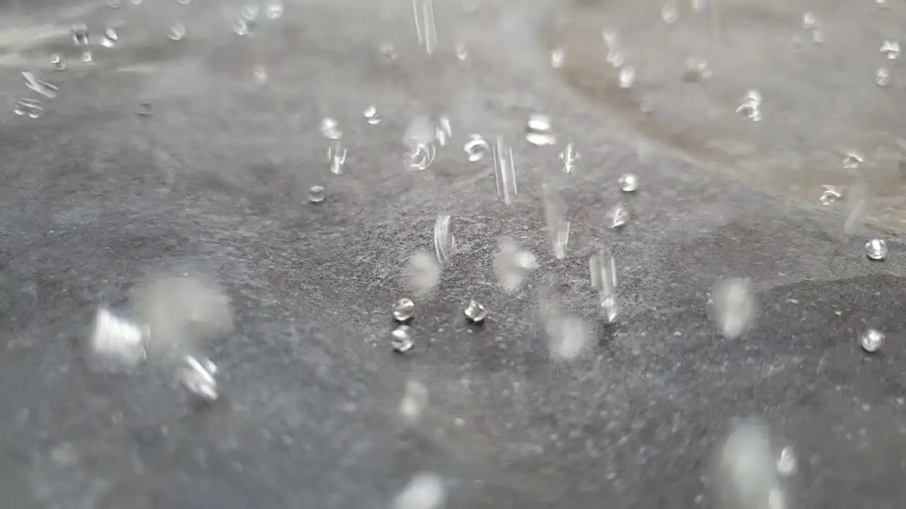 Slow motion bouncing glass beads raining down on ground