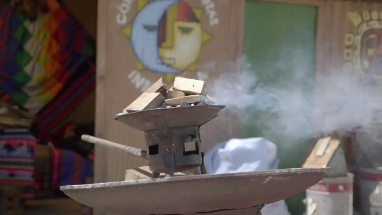 Slow motion shot of outdoor Bolivian fireplace in La Paz Bolivia with color house in background