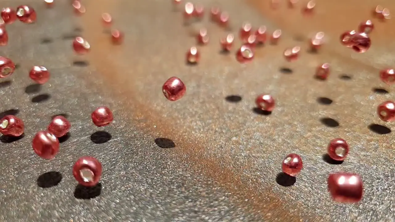 Falling and rolling rose gold glass beads bouncing each other in slow motion