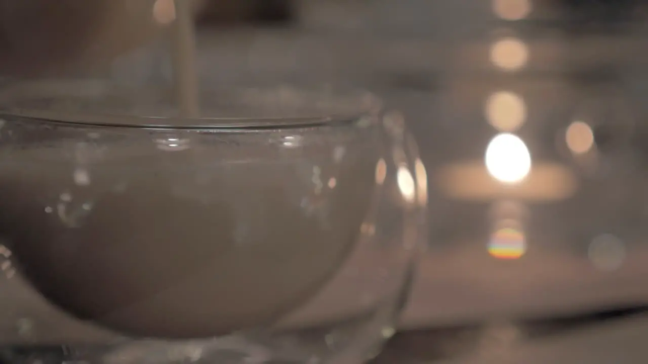 Pouring masala tea into a glass tea bowl