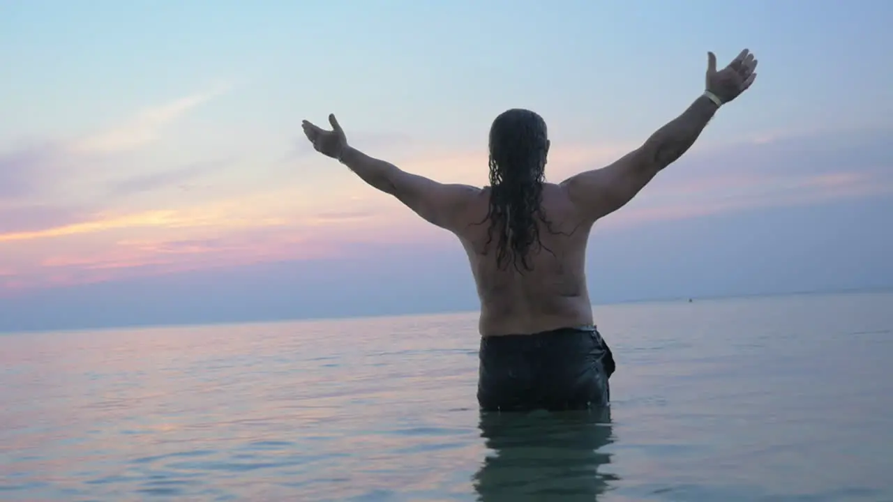 Senior man in water stretching hands