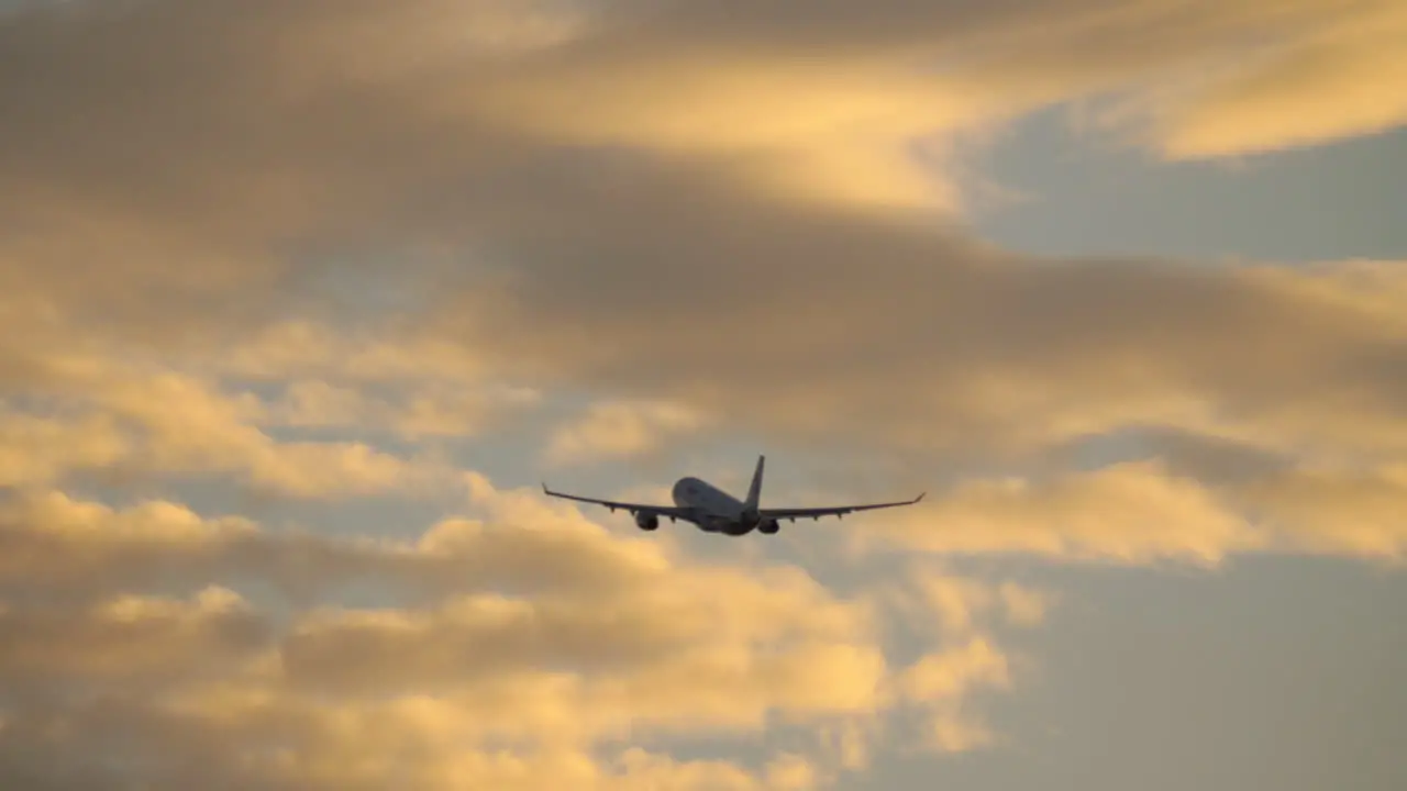 Plane in cloudy evening sky