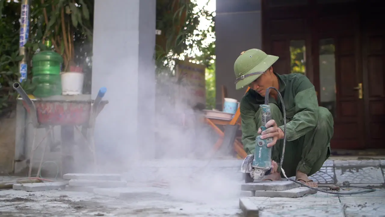 Construction Worker Cuts Tile with Angle Grinder on Roadside