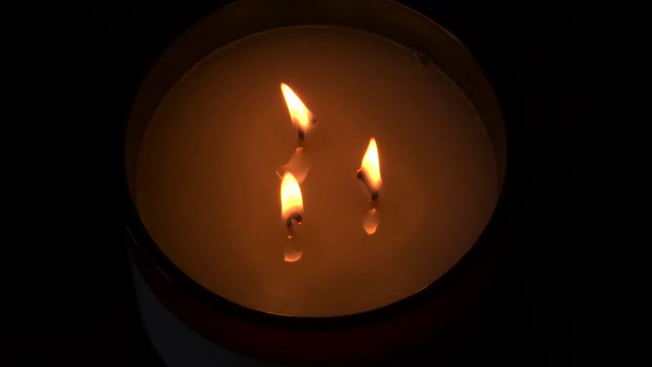 4K slow mo three candles burning with dark background