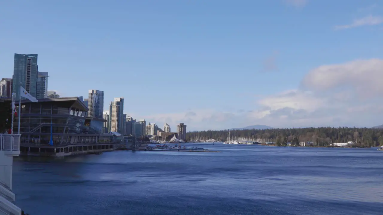 An establishing shot of Coal Harbour with Canada Place flag and windy waters