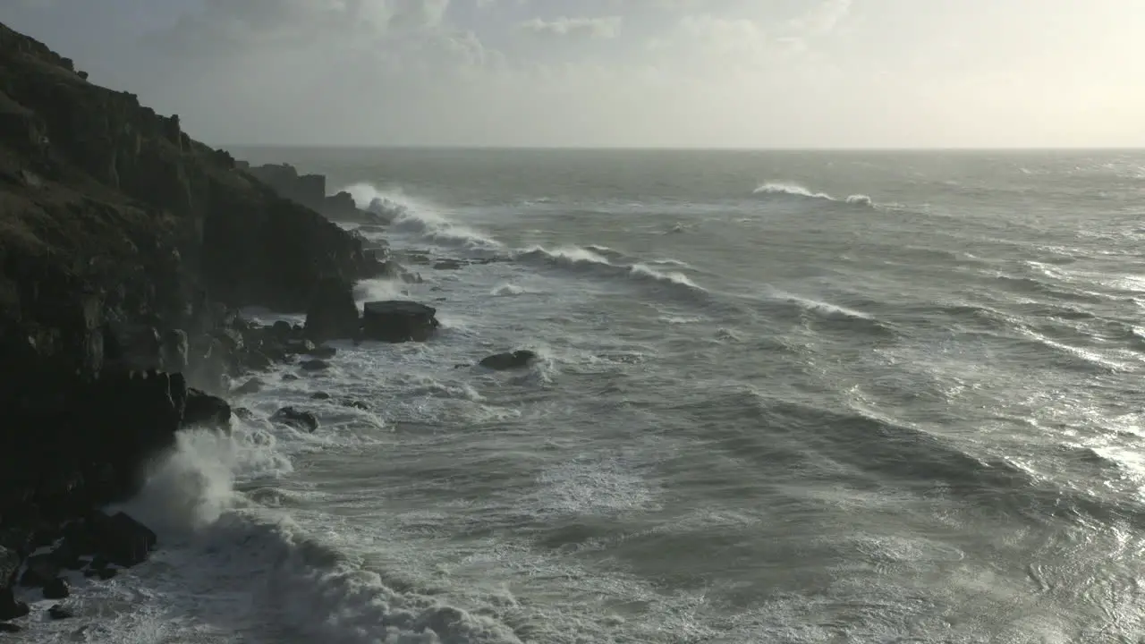 Cinematic dawn shot of waves hitting the coast in Cornwall England