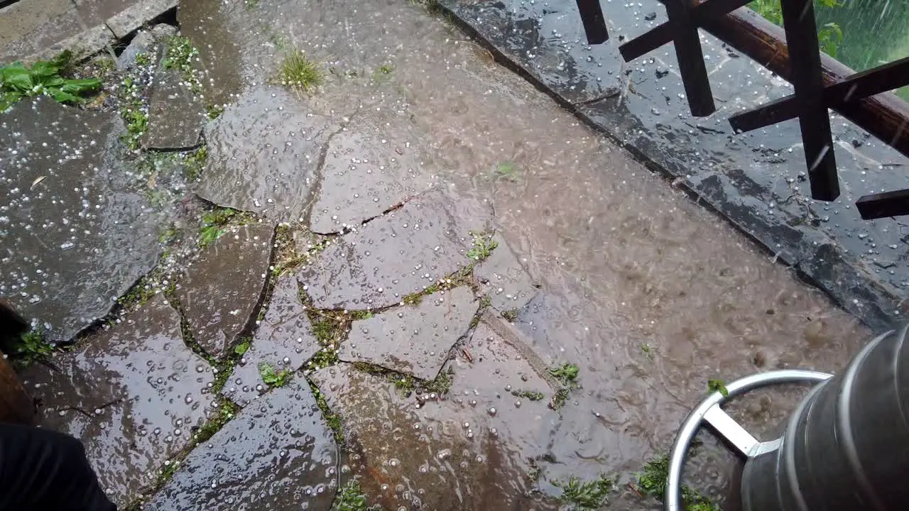 Hail falling on foreground and into puddle Slow motion