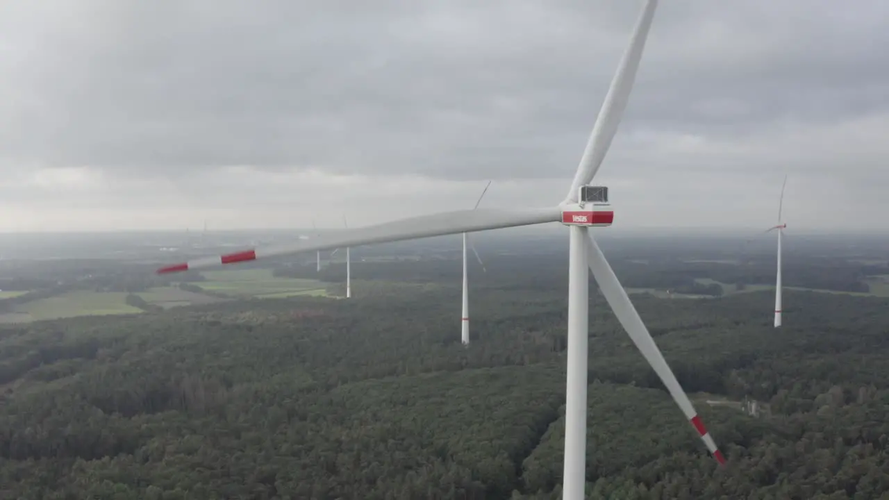 An Orbit drone shot of a wind turbine with more in the background