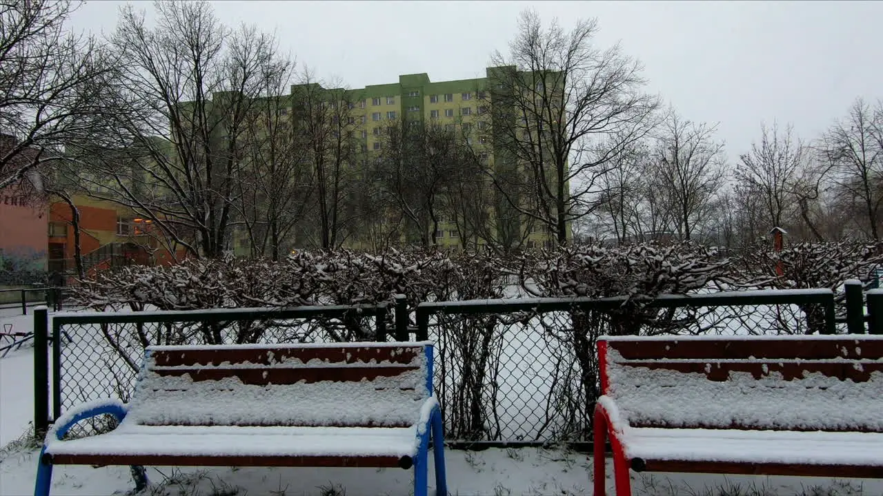 Snow is falling in a city suburb