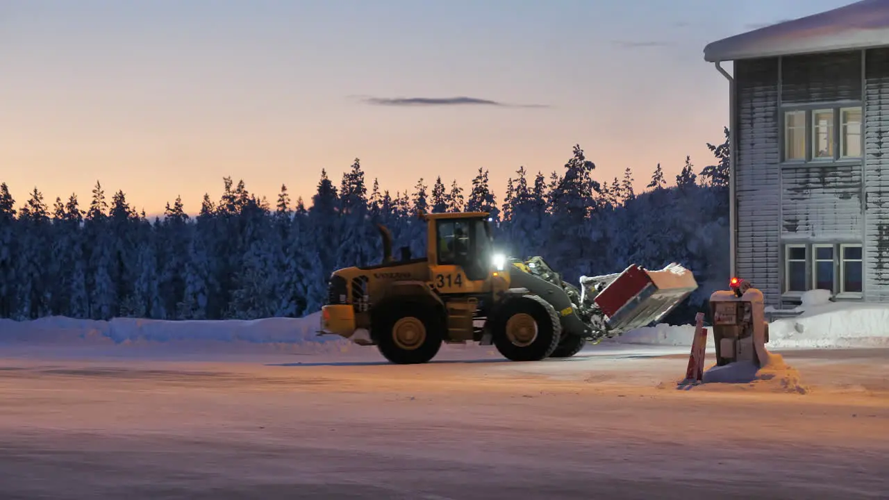 Airport tractor snow removal from apron at Arvidsjaur Sweden at dawn