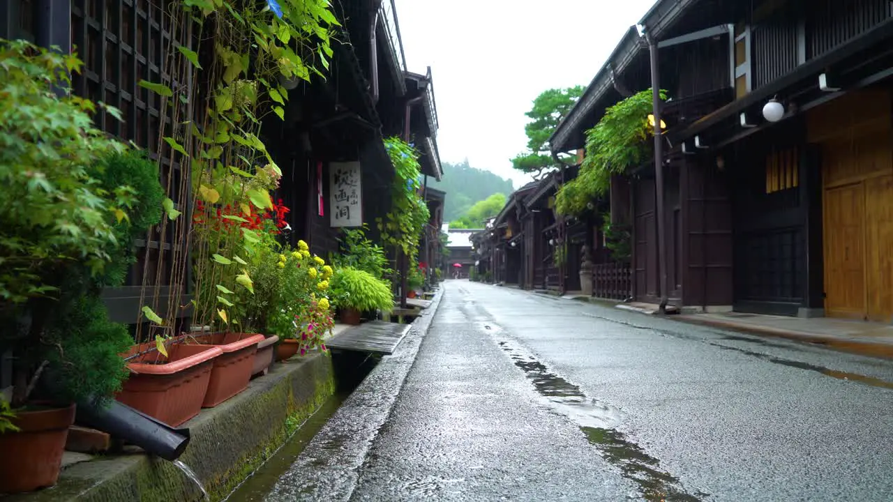 A rainy Sanmanchi Suji street is seen in Takayama Japan and rainwater fills a gutter