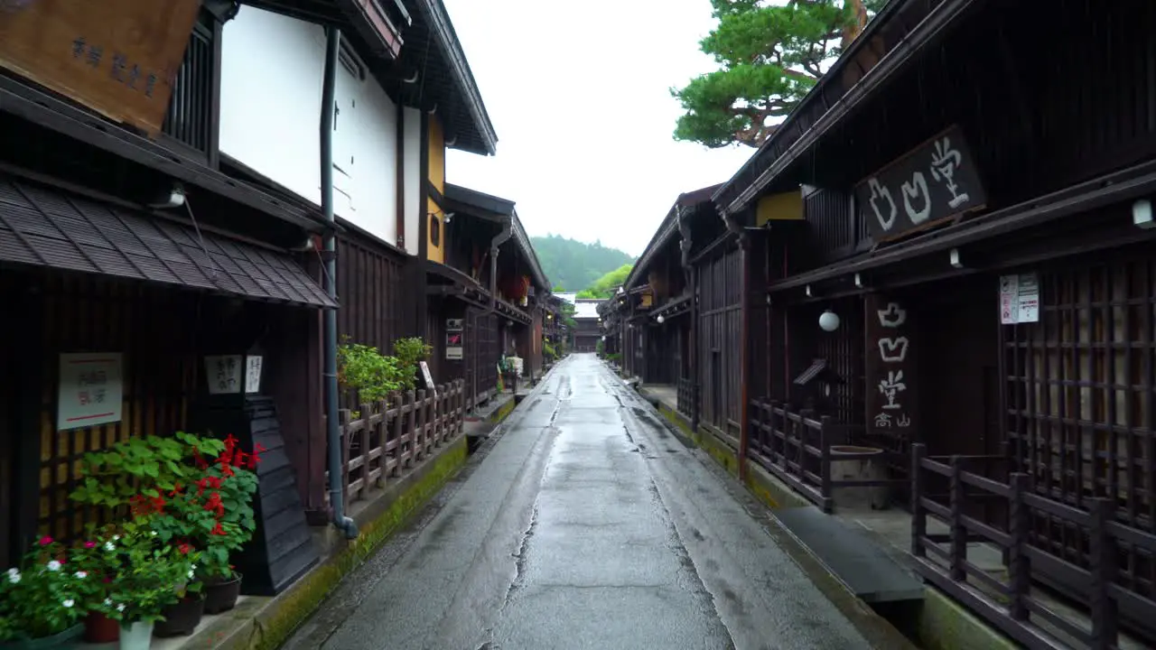 A vehiclemounted camera captures footage as it drives down a rainy Sanmanchi Suji street in Takayama Japan