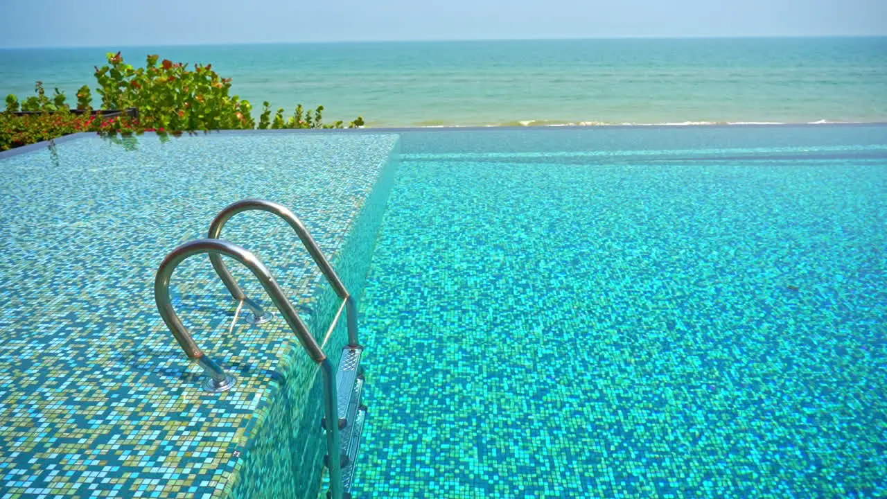 An empty resort pool with the ocean in the background