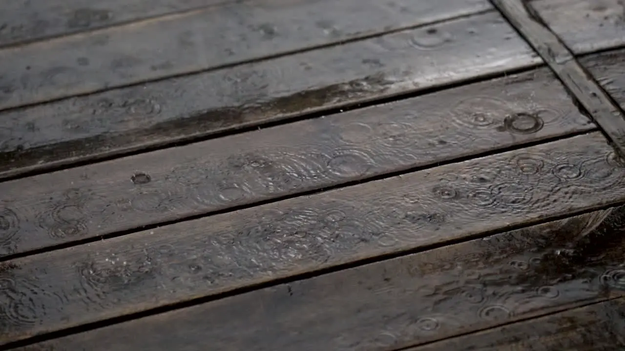 Heavy raindrops on a wooden deck in a garden hr06