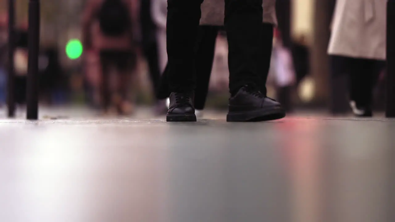 Slow motion footage of black shoes walking on the sidewalk in Paris France