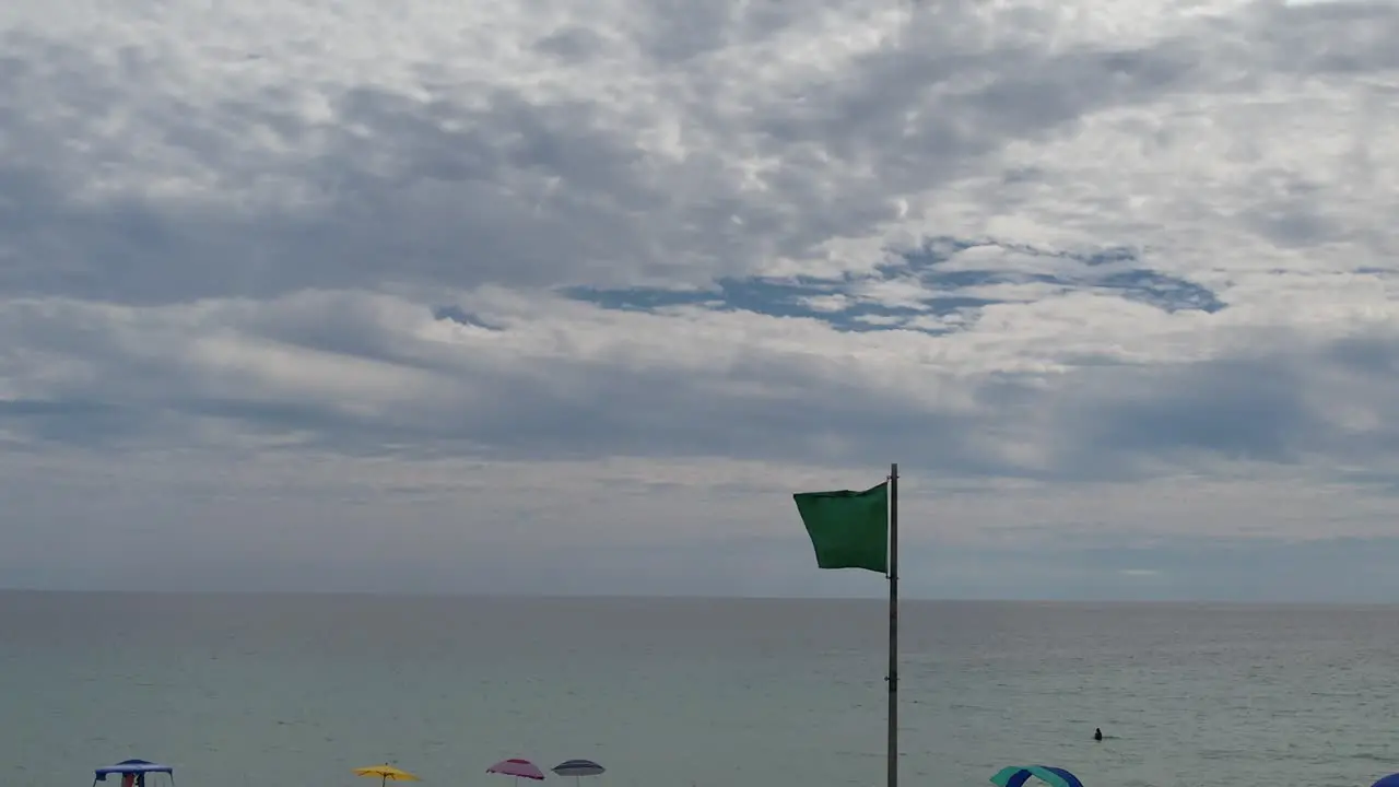 Green flag flying over the clear water of the Gulf of Mexico