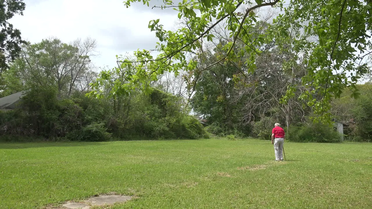 Louisiana man walks on lawn with a cane