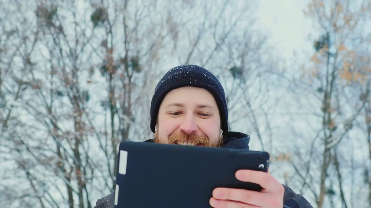 Smiling Man Uses Tablet In Winter Park 02