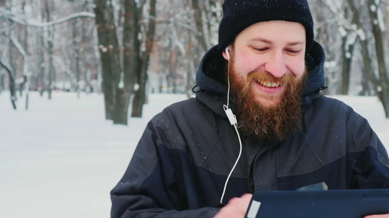 Smiling Man Uses Smartphone In Winter Park