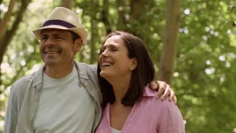 Tracking Profile Shot of Middle Aged Couple Walking In a Scenic Woodland