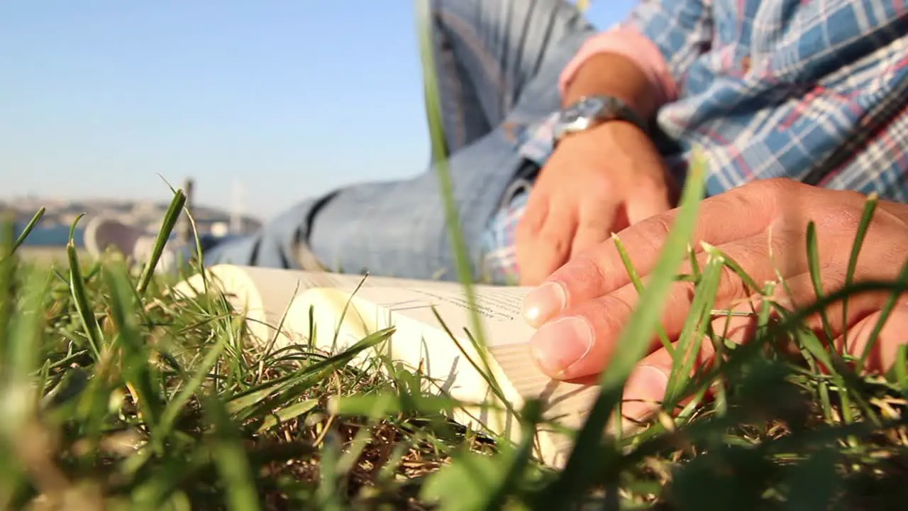 Young Man Reading Book At Park