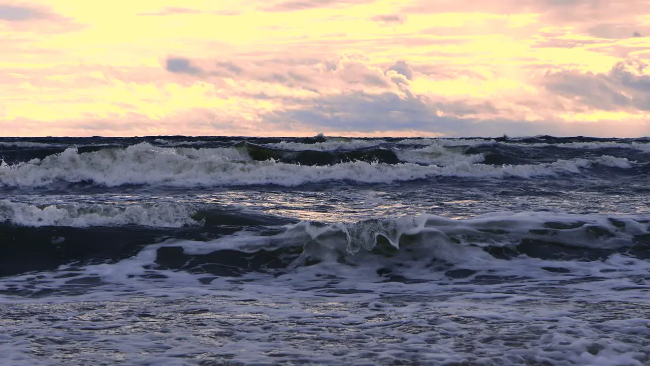 Waves at sea during a thunderstorm at sunset