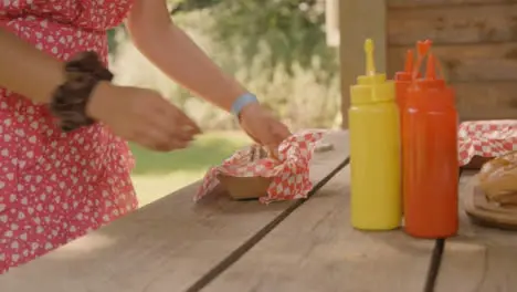 Medium Shot of Young Festival Goer Adding Some Sauce to Hot Dog