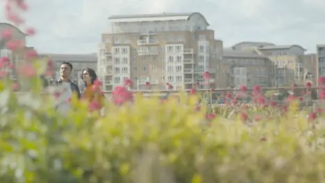 Pull Focus Shot of Two Friends Taking Selfie In Flower Garden