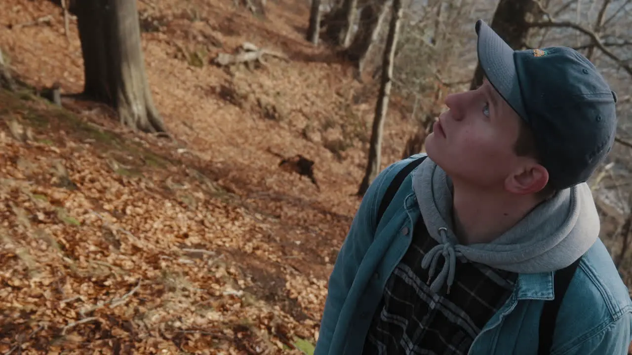 young man with blue eyes watching trees thoughtfully