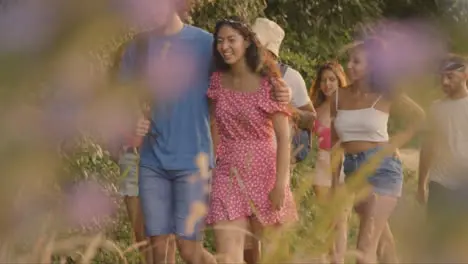 Pull Focus Shot of a Group of Friends Walking Along Rural Countryside Path