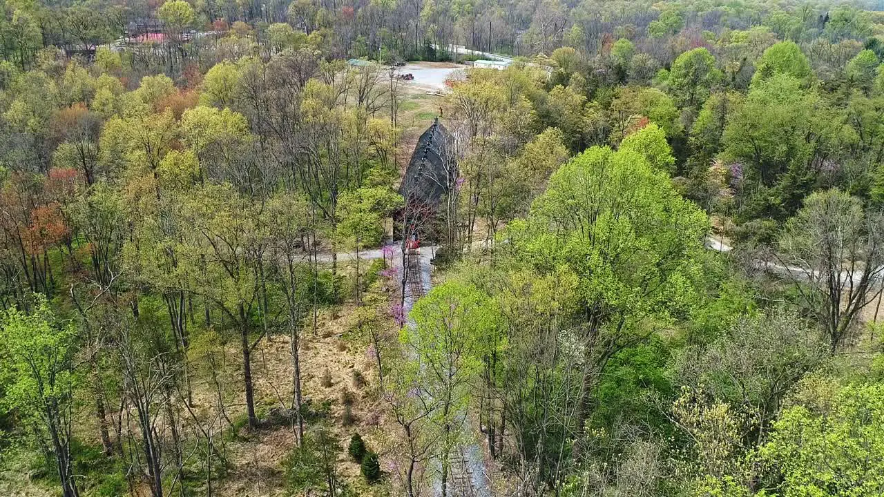 An Aerial View of an 1860's Steam Passenger Train Pulling out of a Train Shed in a Wooded Area on a Lonely Single Rail Road Track