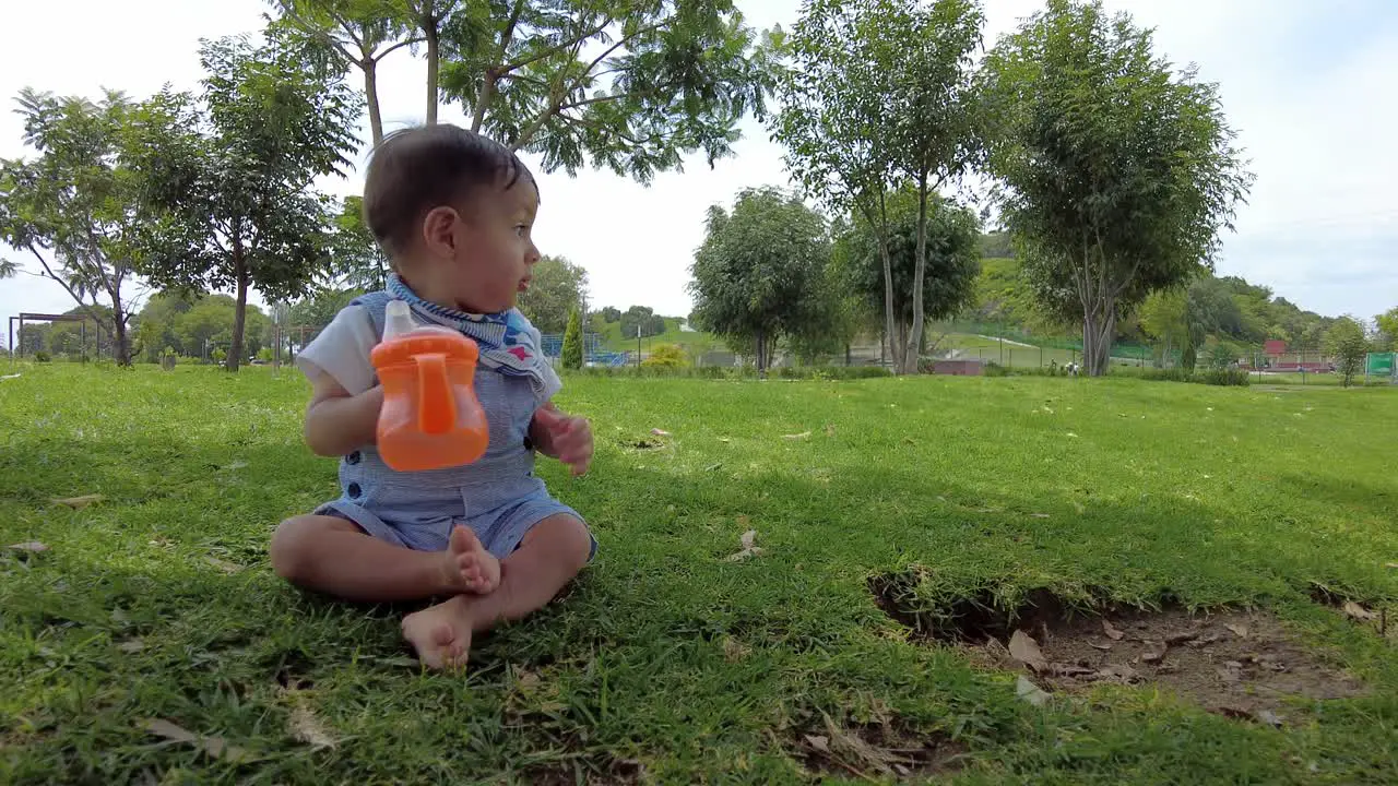 Latin baby boy sitting on the grass at the park in Puebla Mexico