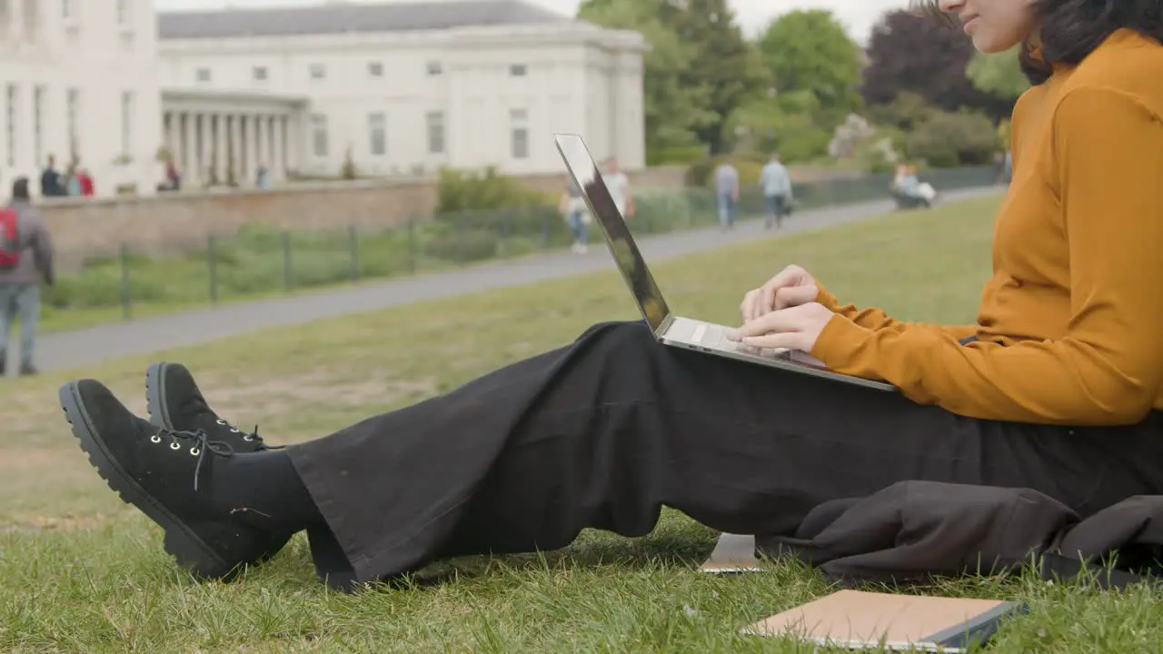 Handheld Shot of Young Woman On Laptop In a Park