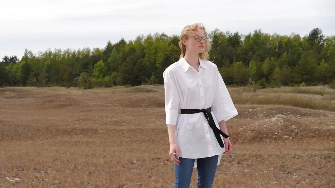 Moving side view of scared woman in dunes waching sea