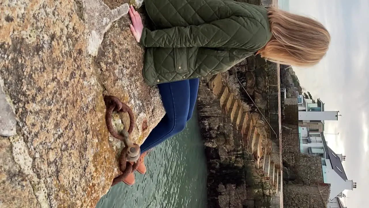 Beautiful young woman sitting on Irish Harbour Smiling