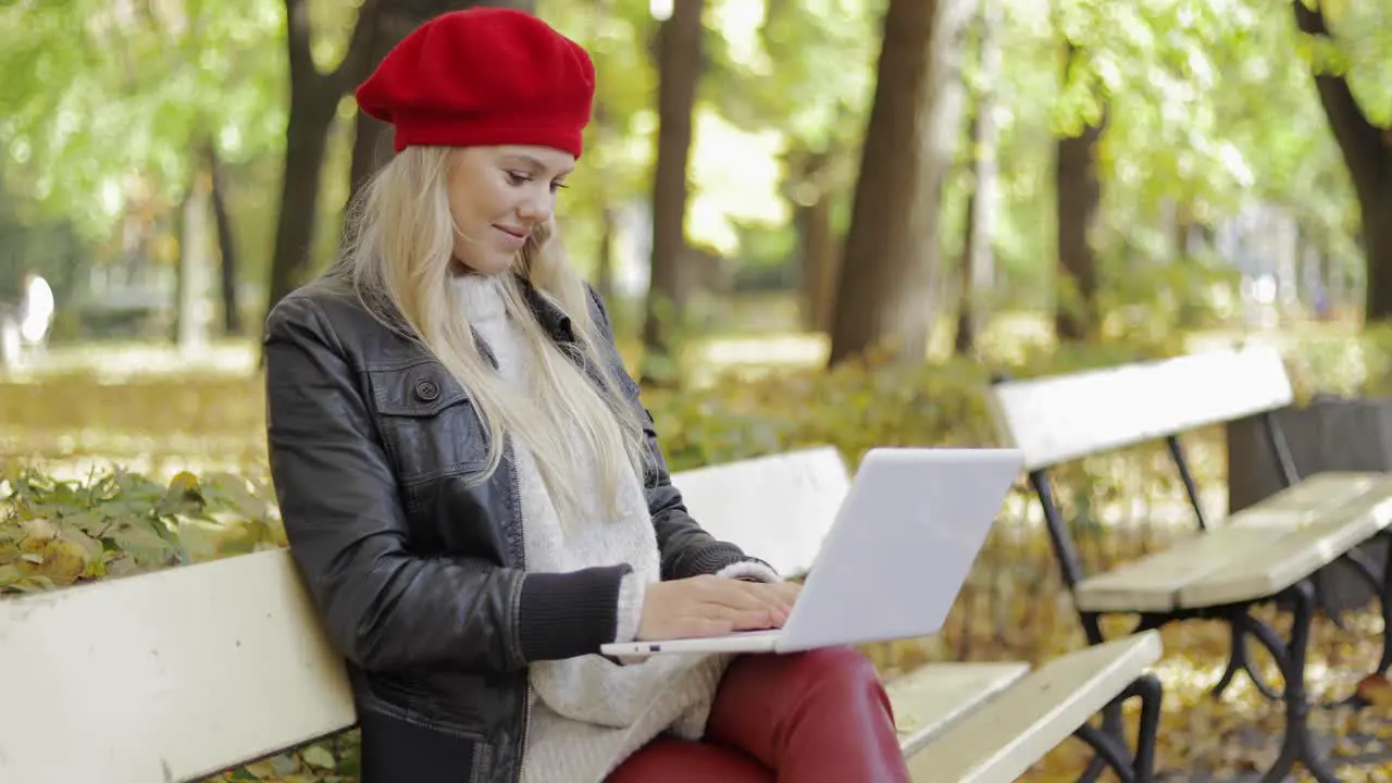 Woman using laptop in autumn park