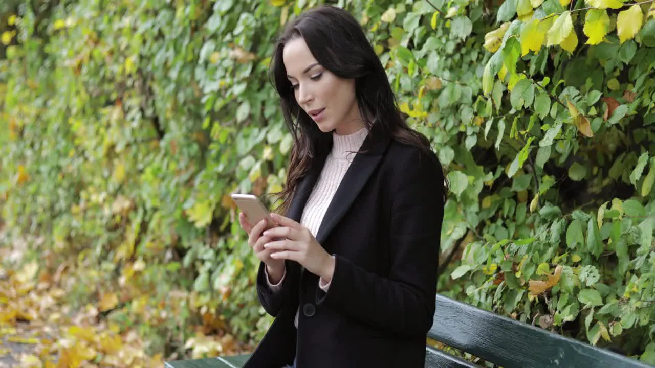 Woman using smartphone on bench