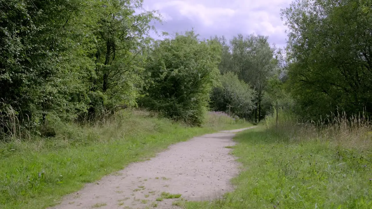 Young woman walking through stamford park with her BMX