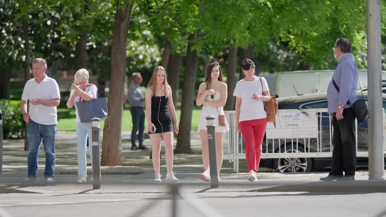 Slow motion scene where mixed people stops at a pedestrian crossing