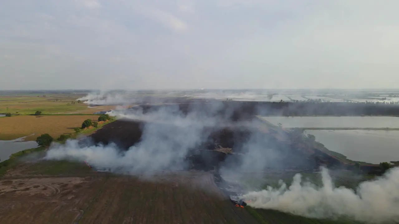 Aerial footage towards burning farmland ready for the next panting season revealing tilled lands and the horizon Grassland Burning Pak Pli Nakhon Nayok Thailand