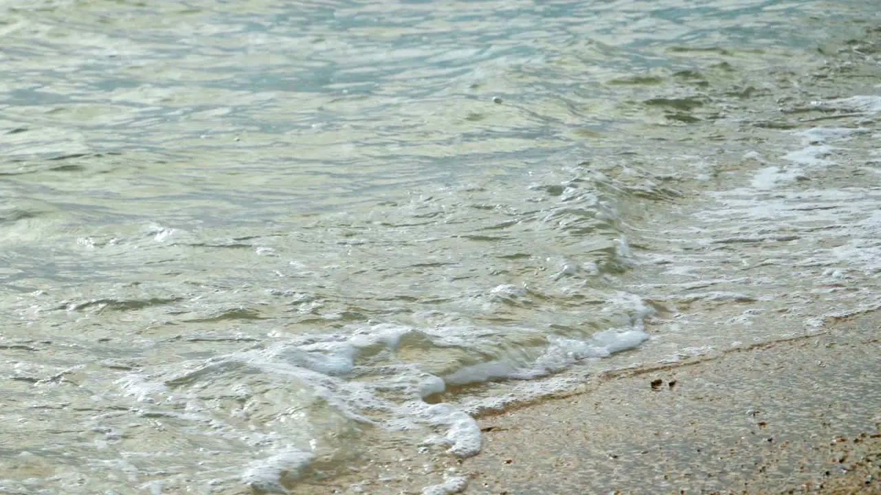 Beautiful beach with waves reaching the shore of a white sand beach on a tropical during a sunset