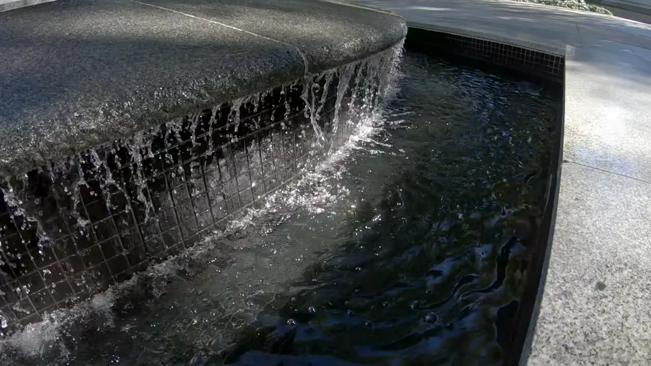 Water running a dripping in slow motion from a man-made fountain