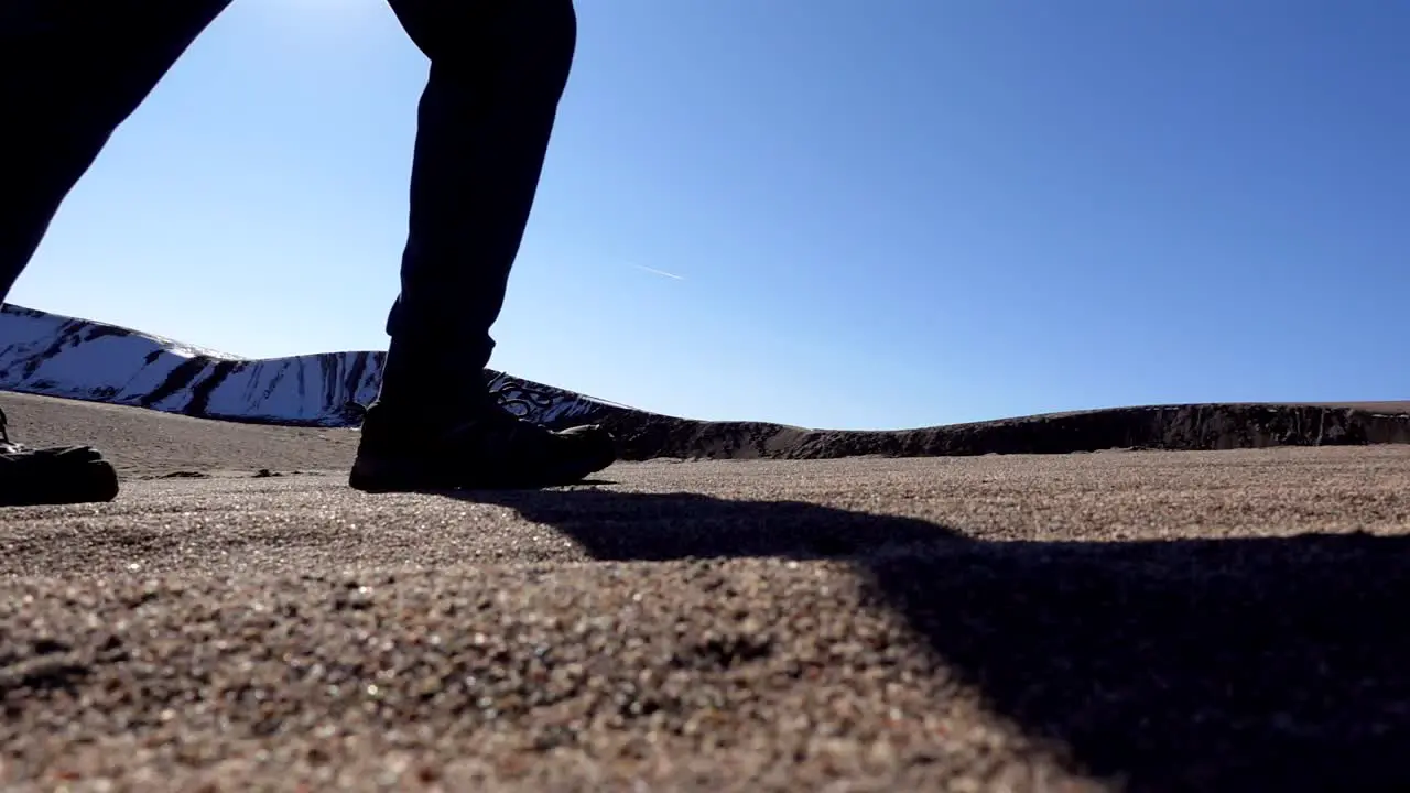 Closeup view of walking on sand dunes in slow motion