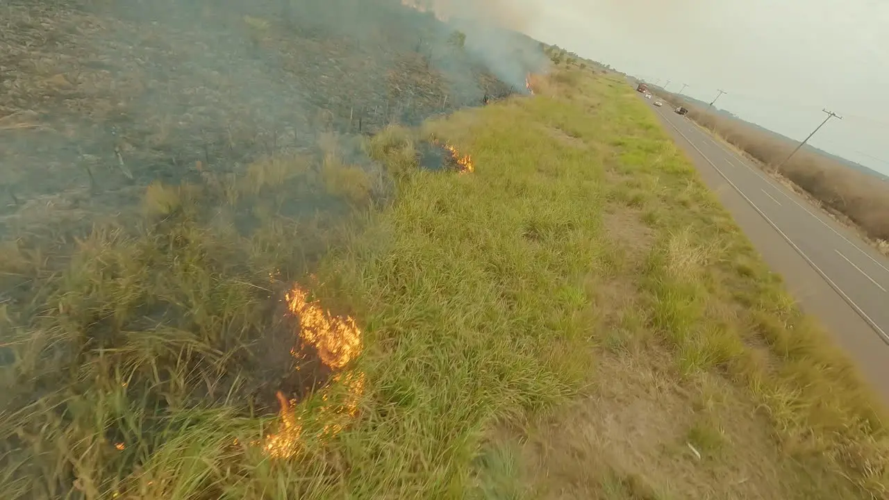 FPV drone flight burning farmland low flyover bushfire smoke and flames speed aerial big flames a lot of smoke grassland burns