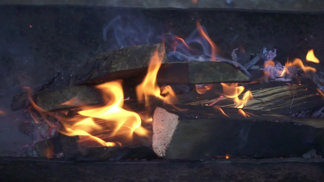 Burning firewood in flame bonfire in brazier before cooking barbeque food