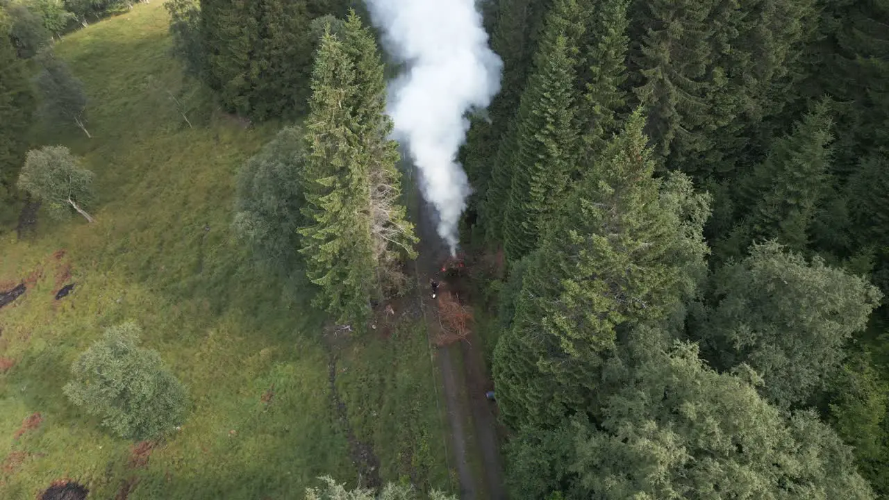 Farmers Feeding a Burning Waste Bonfire on a Path with Ashes Flying around Everywhere in Vik i Sogn Norway